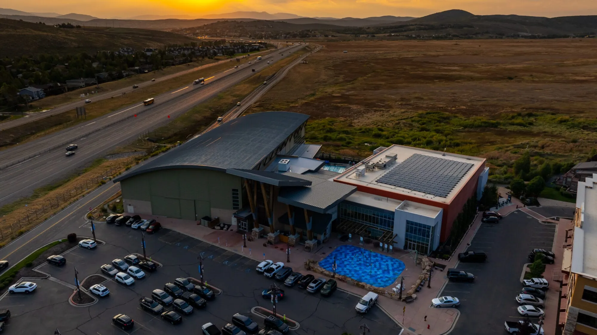 Drone footage of the Basin Recreation Fieldhouse facilty, parking lot, and Swaner Preserve in the background