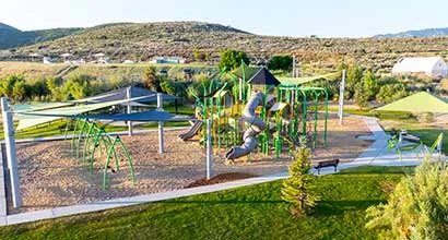 Ariel view of a playground surrounded by green grass.